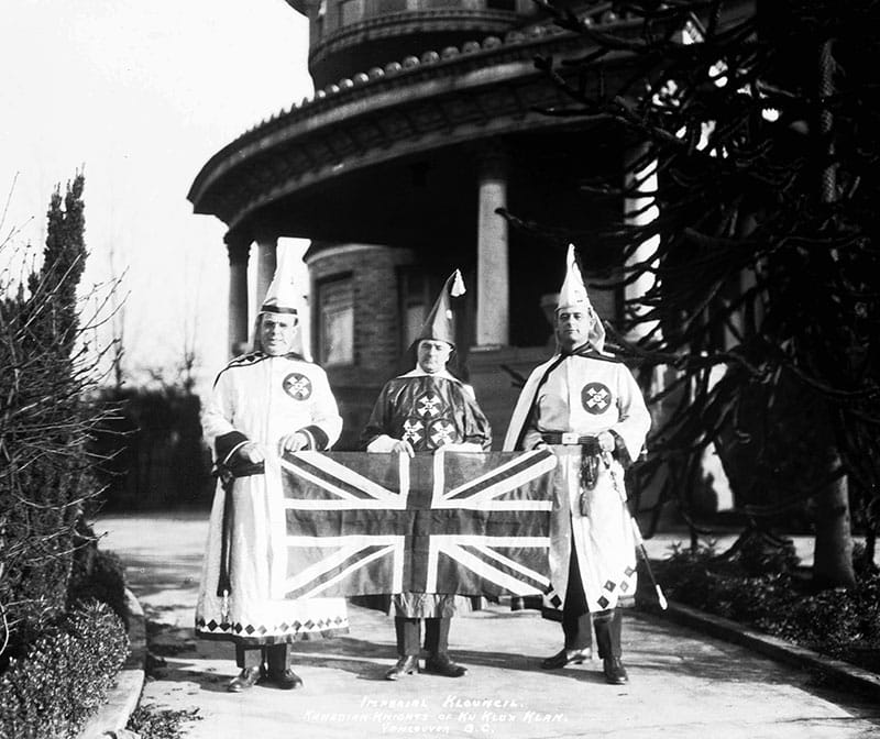 The "Imperial Klouncil" of the KKK outside Glen Brae Manor, holding a Union Jack. Photo by Stuart Thomson, City of Vancouver Archives #99-1496.