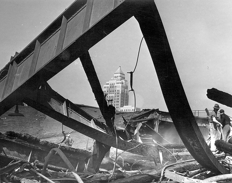 The Marine Building has witnessed some history over the past 88 years. Here it is through the charred remains of the CPR's Pier D, which was destroyed in a spectacular fire in 1938. Photo by Stan Williams, City of Vancouver Archives #Can P61.2.