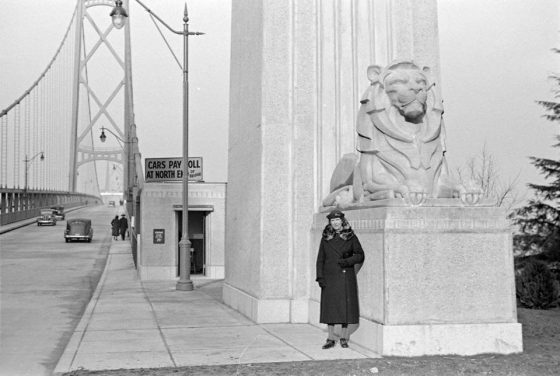 Woman stands at the entrance to the Lion's Gate Bridge