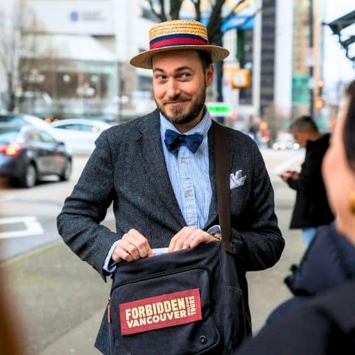 Guide Rob Reaching into his Forbidden Vancouver bag with a mischievous grin on his face
