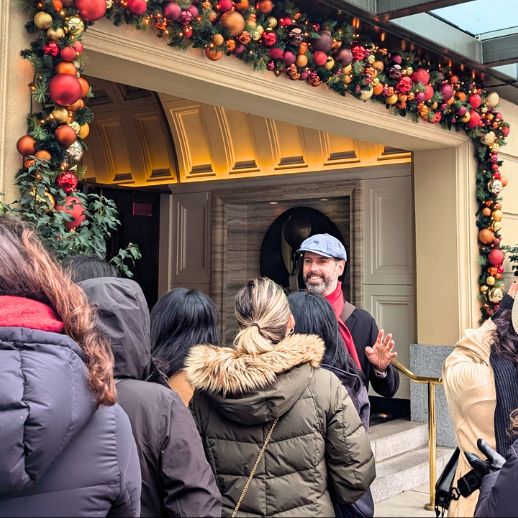 A guide smiles in front of a doorway decorated in holiday baubles at the Hotel Georgia in downtown Vancouver