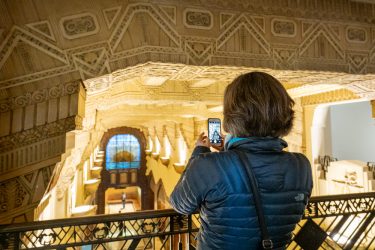 Best Vancouver Experiences for Senior Travellers 2 A guest on a senior-friendly walking tour photographing the Art Deco lobby of the Marine Building, one of the best Vancouver experiences for senior travellers.